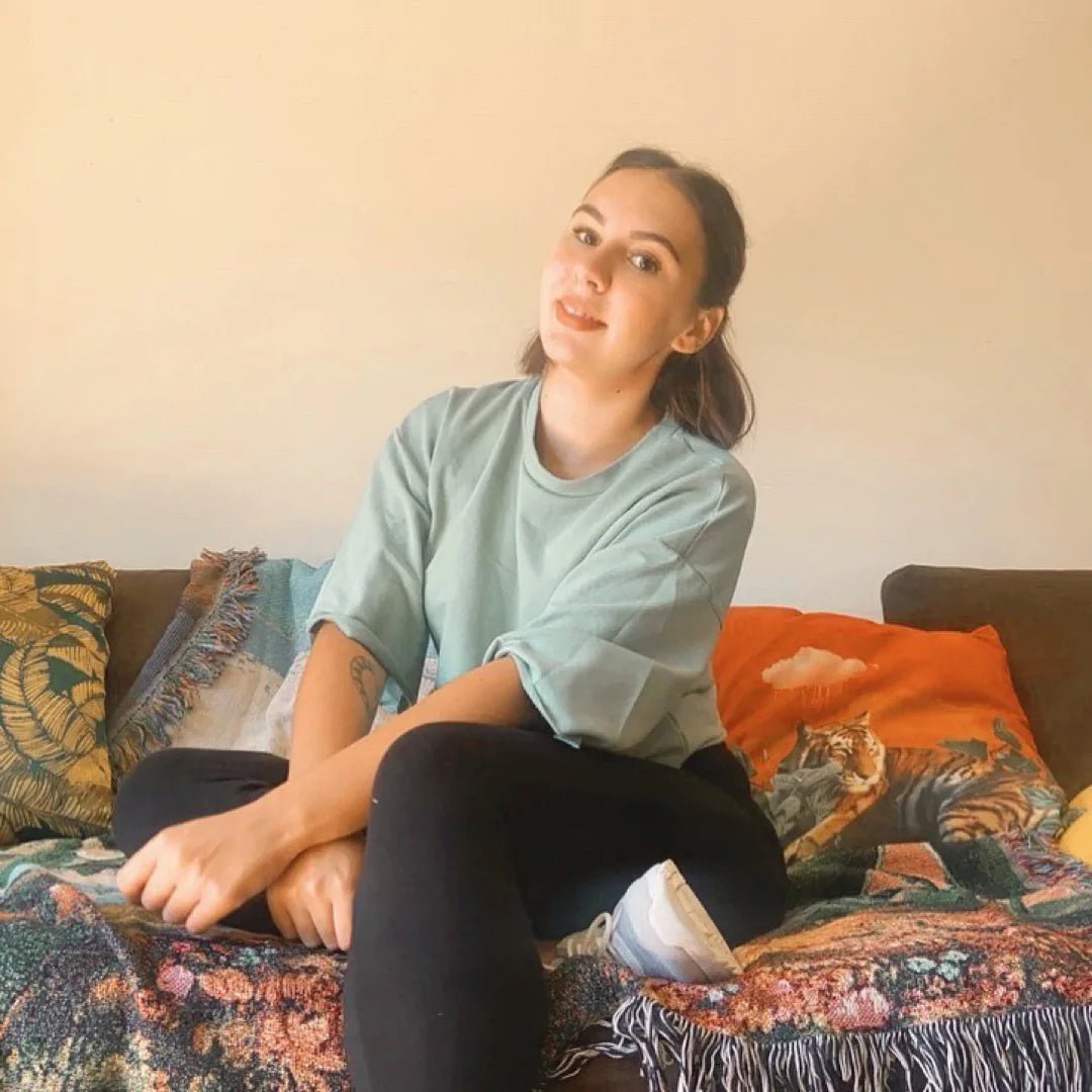 Emma Rodriguez from Mooncrab Co who did a collab with Klint care. She is sitting a couch